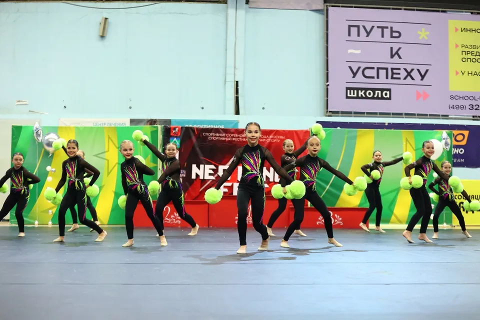Группа выступает с салатовыми помпонами на соревнованиях