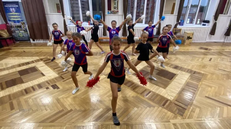 Тренировка в зале: дети повторяют движения с помпонами